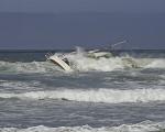 Efforts to tow a sailboat run aground on Pacifica State Beach fail. Craft sinks with the recovery crew still aboard