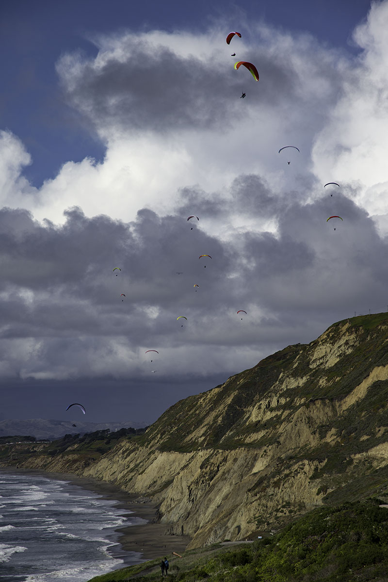 Parasailers frolic in the sky above Mussel Rock in Pacifica