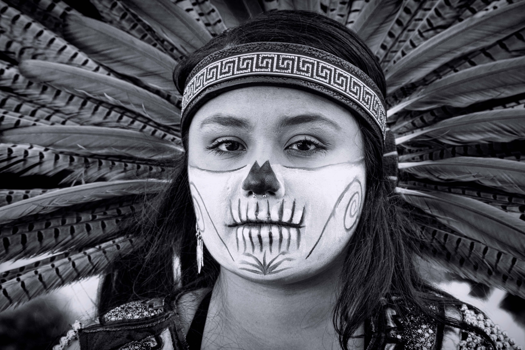 Portrait of an Aztec girl with feather head-dress on Dias de los Muertos.