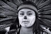 Portrait of an Aztec girl with feather head-dress on Dias de los Muertos.