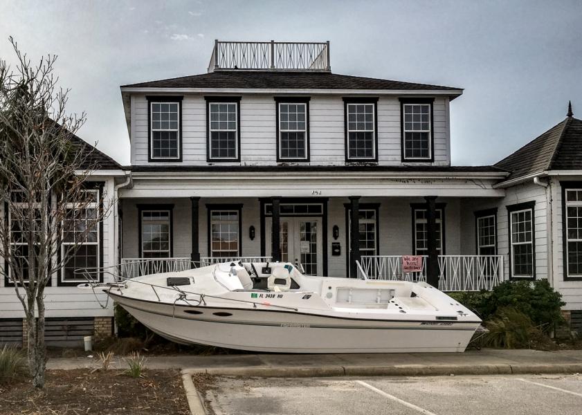 'We Are Here, Go To Back' A sign directs customers to the back door when a boat blocks the front entrance after Hurricane Michael devastates Port St. Joe, FL in October 2018
