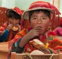 Quechuan Schoolboy eats a snack, Urubamba Valley, Peru