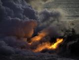 Lava from Kilauea flows into the ocean forming new land and a steam cloud laced with hydrochloric acid.