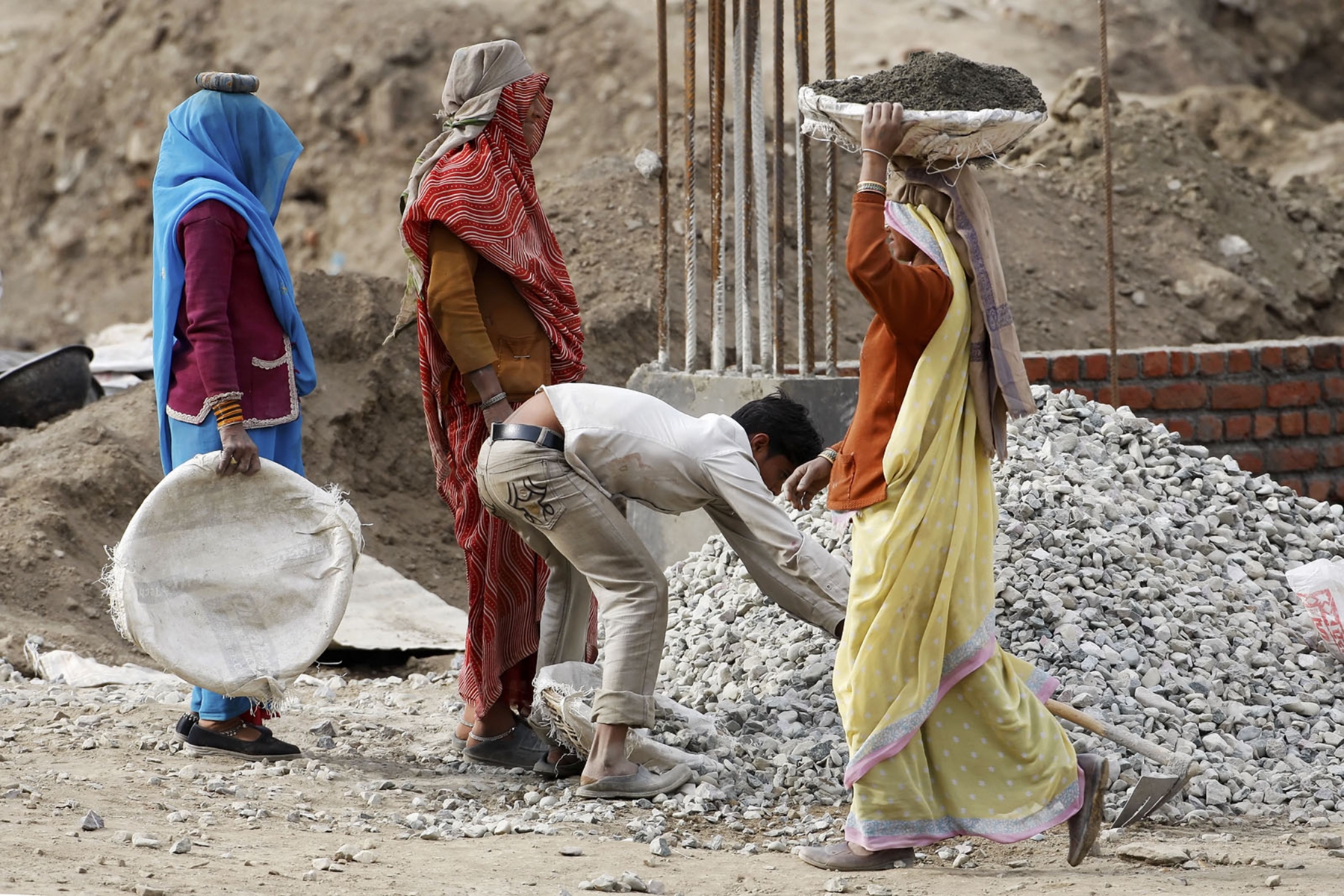 In India, Woman are the Major Work Force. Here Carrying Material to the Cement Mixer